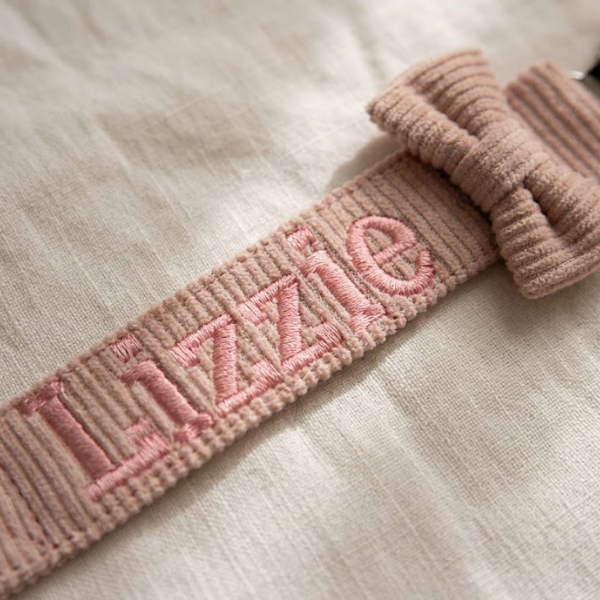Detail van roze borduurgaren op corduroy speenkoord met naam Lizzie